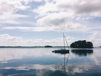 Boats in sea against cloudy sky