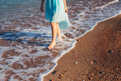 Low section of people standing on beach