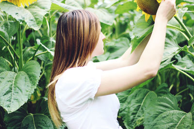 Rear view of woman standing by plants