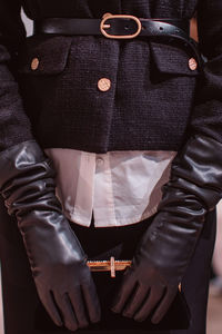 Fashion details classy black jacket, leather belt, gloves, velvet clutch. fashion model on backstage