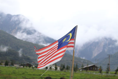 Flag on mountain range against sky