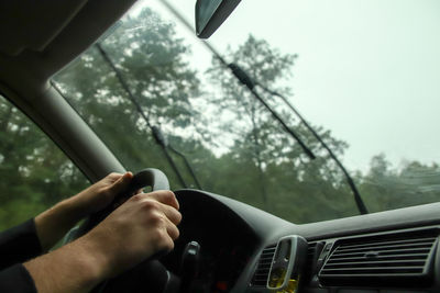 Cropped hand of man driving car