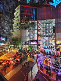 People at illuminated sony center in city