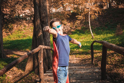 Portrait of boy gesturing in superhero costume in park