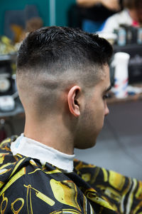 Male customer with hairstyle sitting at salon