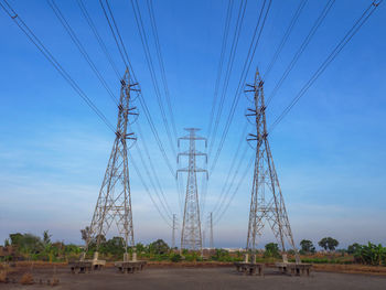 High voltage transmission towers with electricity power line over blue sky and white cloud