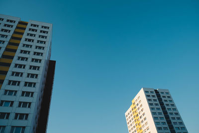 Low angle view of buildings against clear blue sky