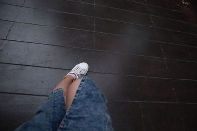 Low section of woman standing on tiled floor