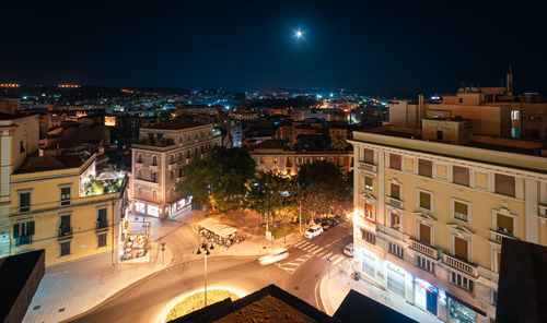 High angle view of illuminated buildings against sky at night