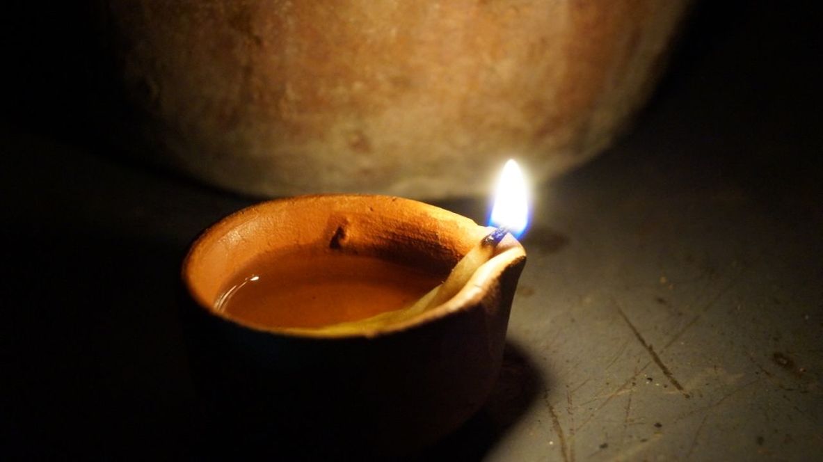 CLOSE-UP OF ILLUMINATED CANDLE