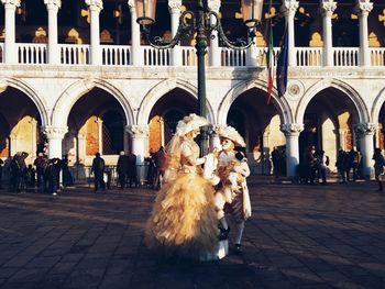Man and woman in costume during venice carnival on street