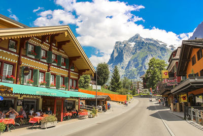 Buildings by road against sky in city