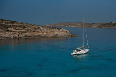 Sailboat sailing in sea against clear sky