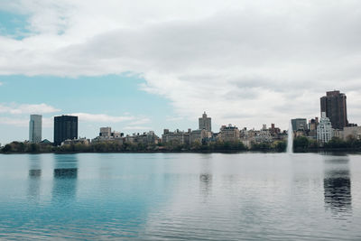 City by river against sky