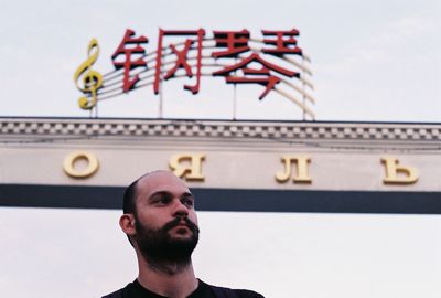 Close-up of man against gate in city