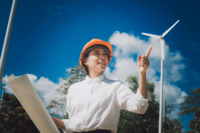 Low angle view of woman standing against sky