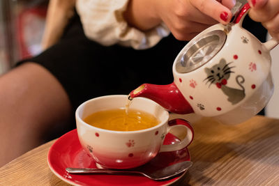 Midsection of woman having coffee