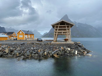 Traditional building by sea against sky