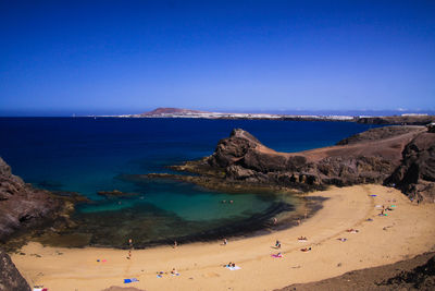 Scenic view of beach against clear blue sky