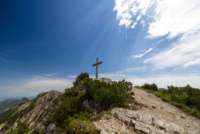 Rear view of man standing on mountain against sky
