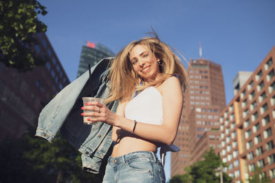 Portrait of beautiful woman with tousled hair in city