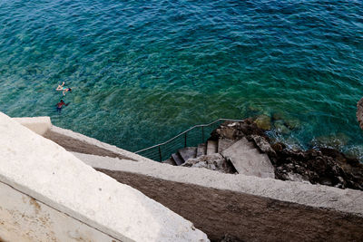 High angle view of steps and rocks by sea