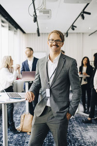 Portrait of smiling businessman standing in office seminar