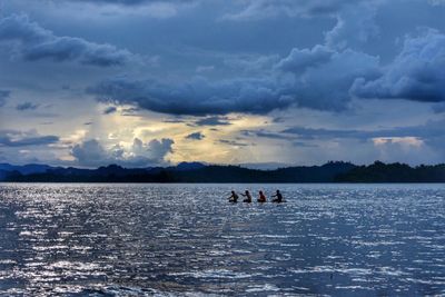 People in lake against sky