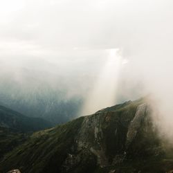 Scenic view of mountains against cloudy sky