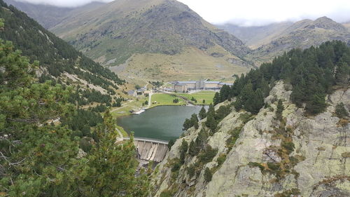 Scenic view of river by mountains against sky