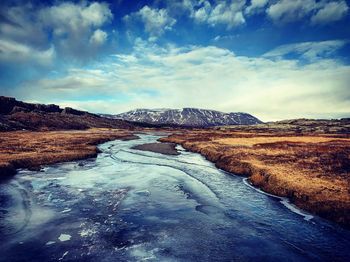 Surface level of road on snow covered landscape against sky