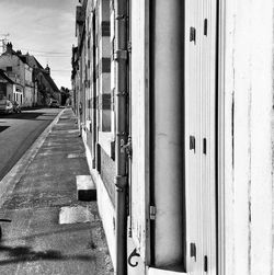 Empty road amidst buildings in city