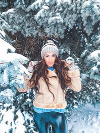 Portrait of young woman standing in snow