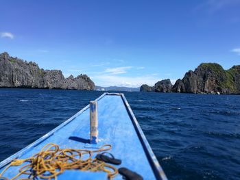 Boat sailing in sea against blue sky