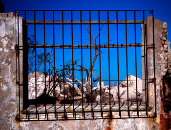 Close-up of metal window against sky