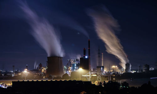 Smoking emanating from chimneys of industry at night