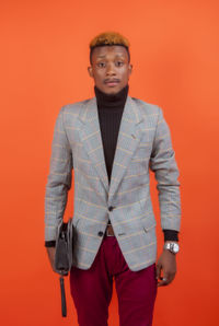 Portrait of young man against red background