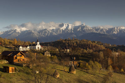 Scenic view of townscape against mountains and sky