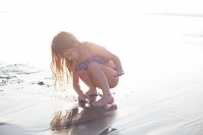 A child independently explores a beach in beautiful light setting.