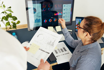 Woman entrepreneur discussing financial data with her colleague in office. people working together