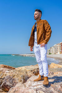 Full length of man standing by sea against clear sky