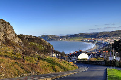 Empty road against calm blue sea