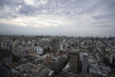 Aerial view of city against cloudy sky