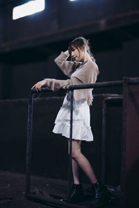 Side view of young woman standing in factory