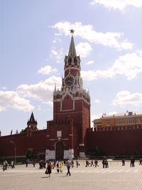 People in front of clock tower against sky