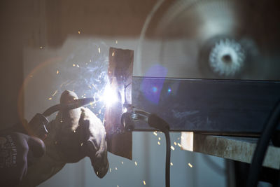 Detailed side view of welder working in shop.