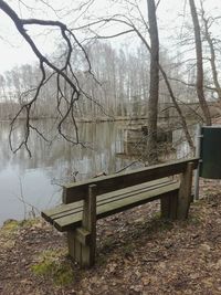 Empty bench in park by lake
