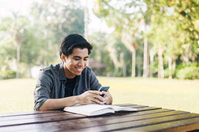 High angle view of man using phone while sitting at table