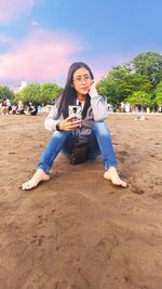 Portrait of young woman sitting at beach