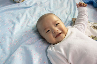 High angle view of baby lying on bed